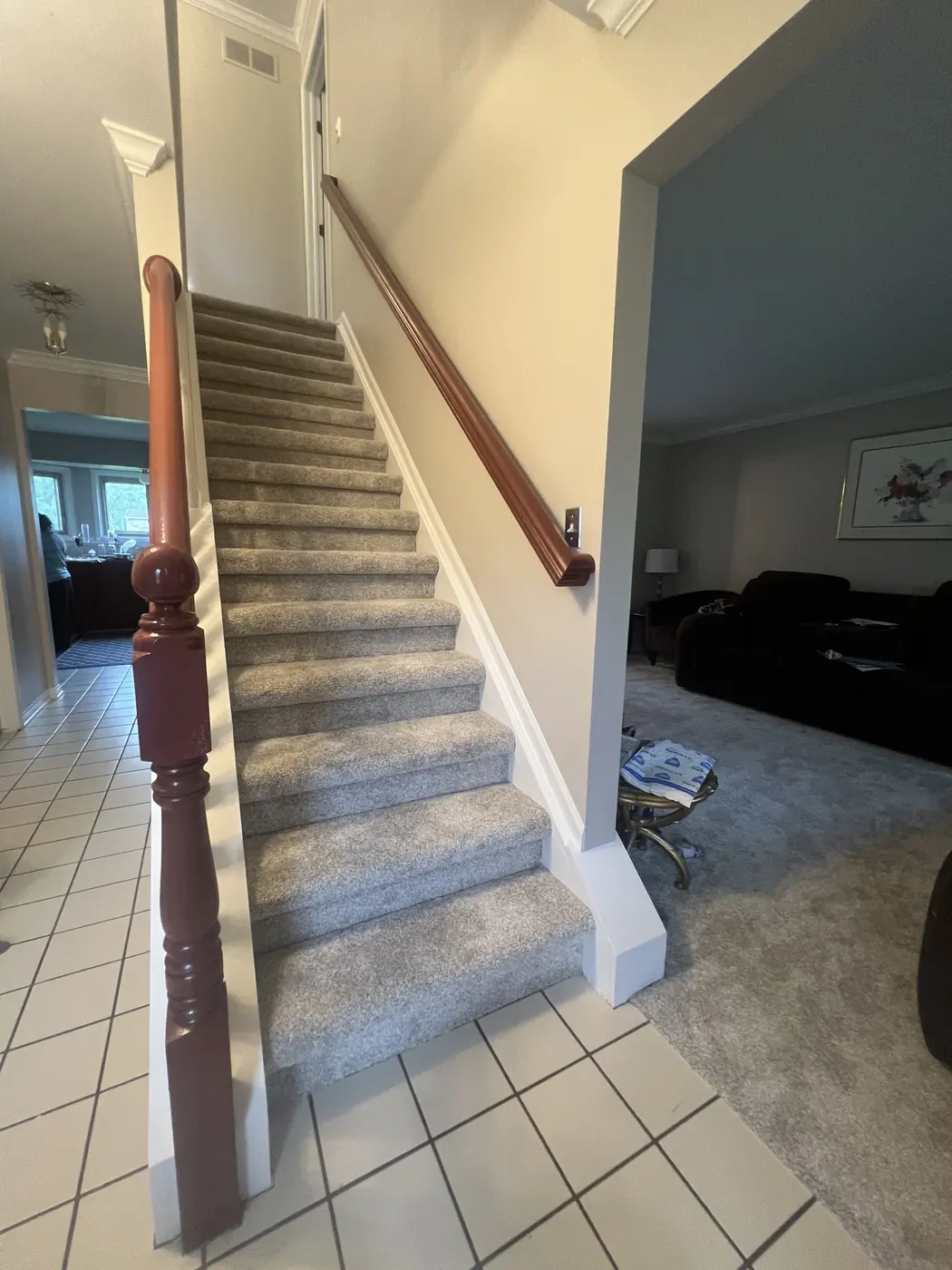 A staircase with a painted rail, white spindles and a wood banister.