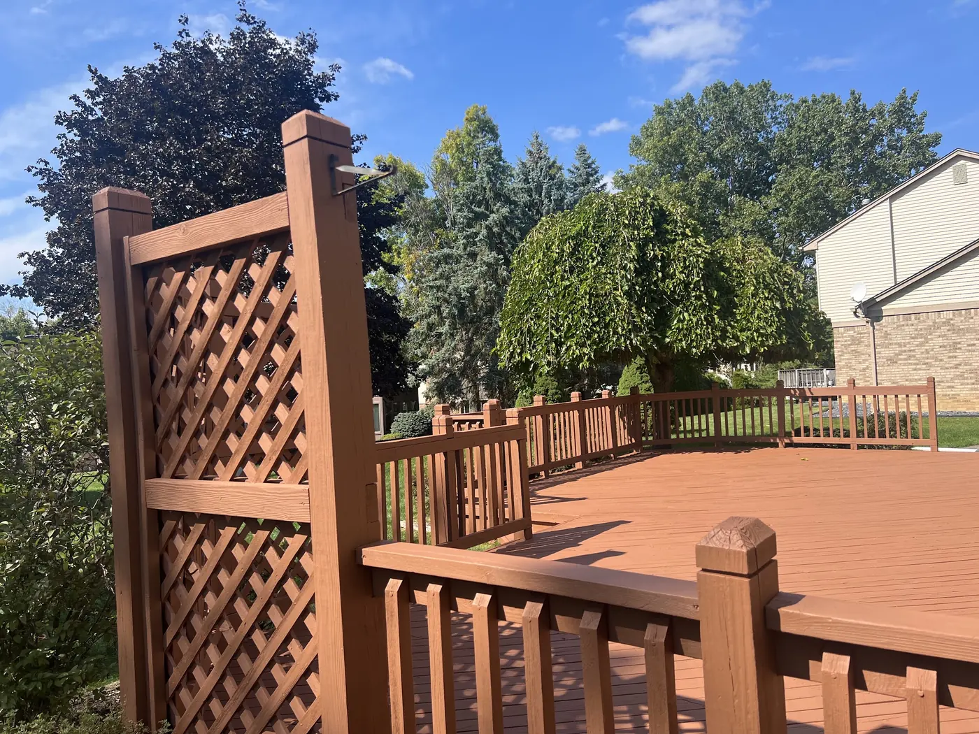 Deck boards and lattice screen finished in a deep terracotta stain.
