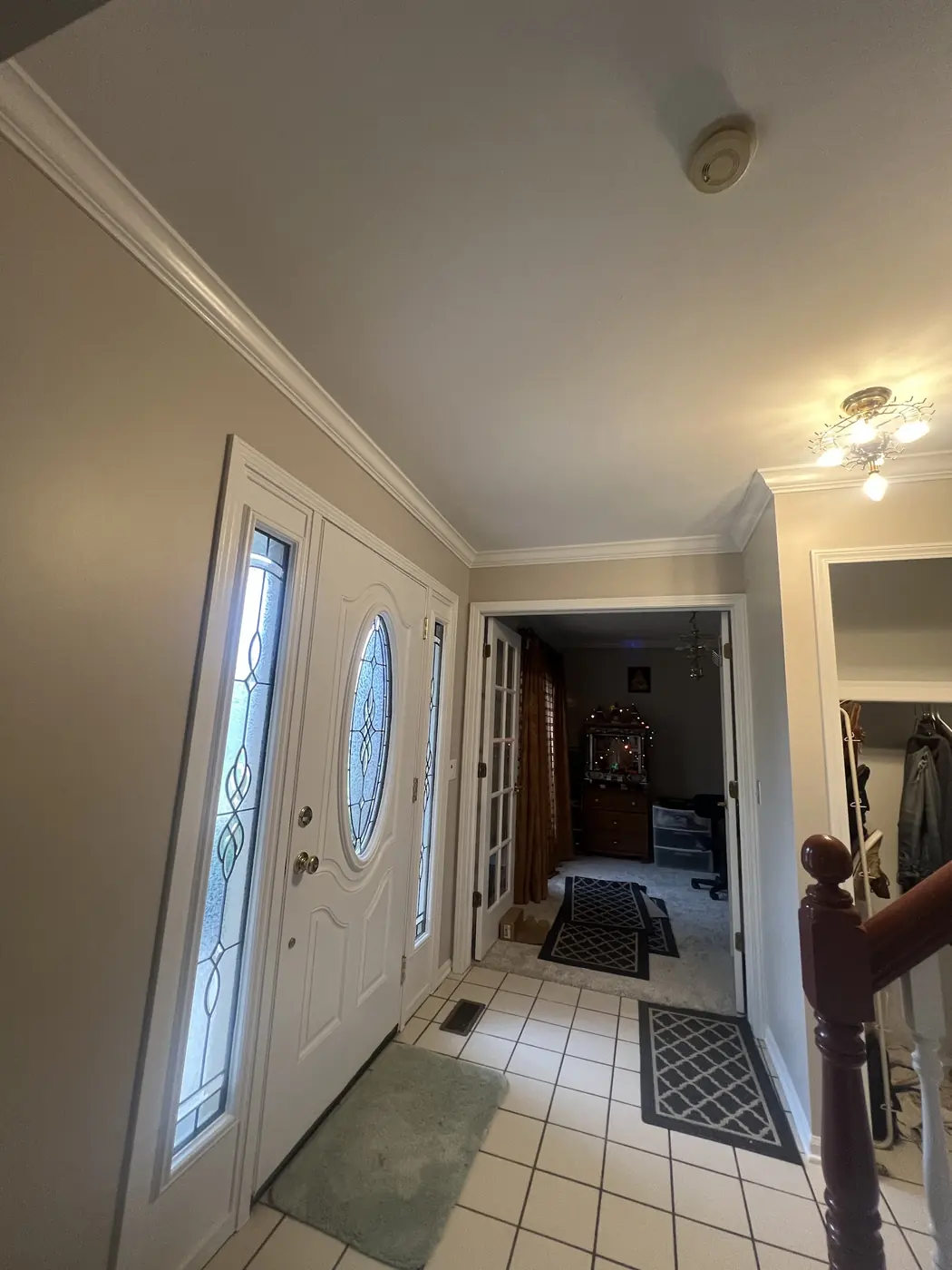 A hallway with crisp white trim, doors and crown moulding.