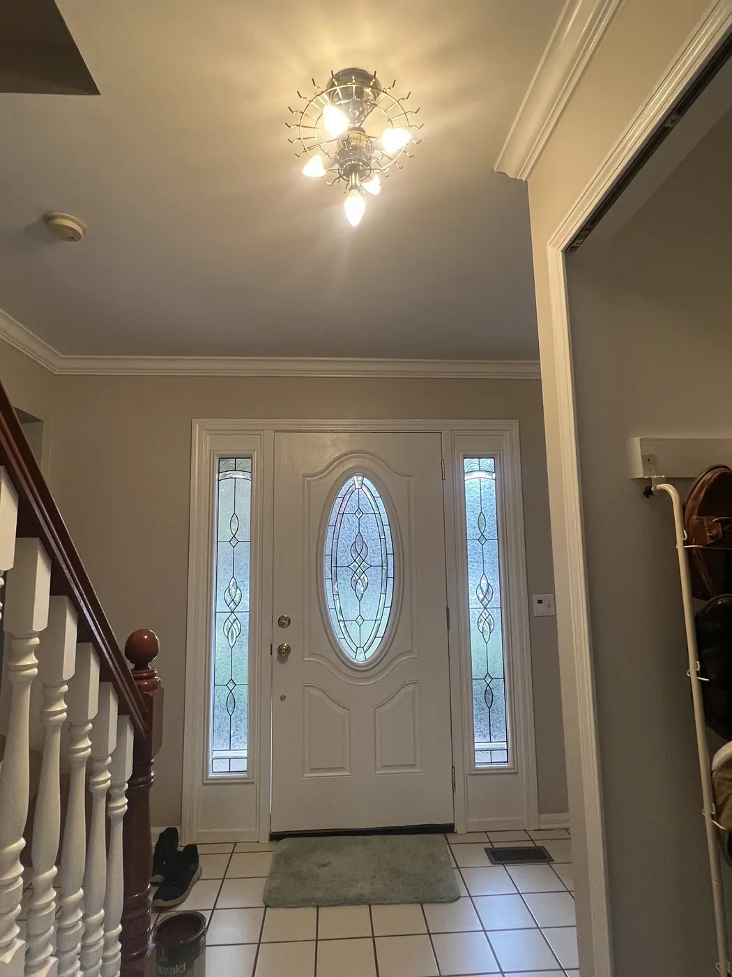 An entry hall with a chandelier, freshly painted walls and white trim.